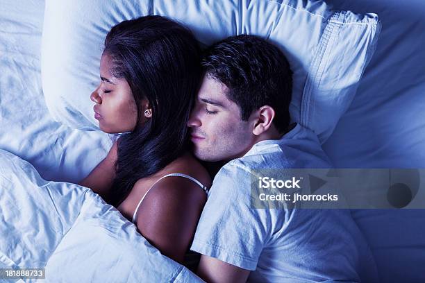 Szczęśliwy Młody Mieszanej Rasy Para Spanie W Łóżku - zdjęcia stockowe i więcej obrazów Na łyżeczkę