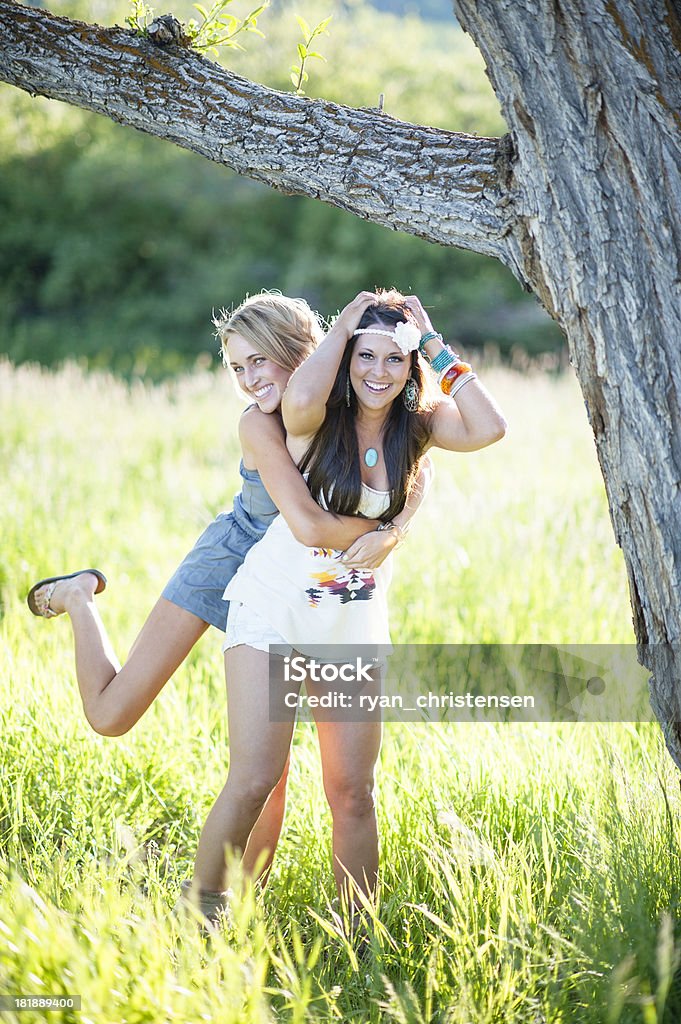 Estilo de Vida: Duas belas mulheres pendurado em um galho de árvore - Foto de stock de 20 Anos royalty-free