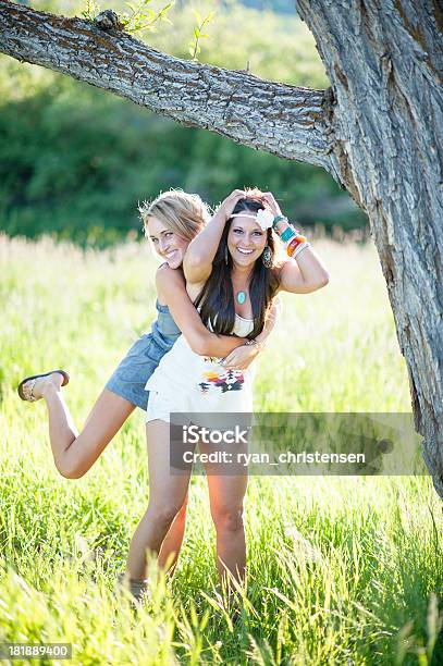 Foto de Estilo De Vida Duas Belas Mulheres Pendurado Em Um Galho De Árvore e mais fotos de stock de 20 Anos