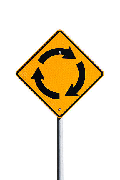 A close-up of a two-way traffic sign against a clear blue sky.