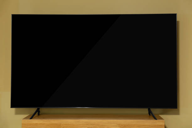 istock Modern plasma TV on wooden table near beige wall 1818904430