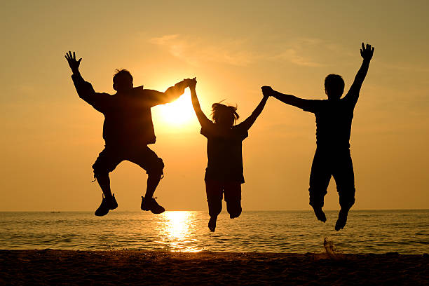istock Silhouette Group of happy people  jumping on the beach 181890706