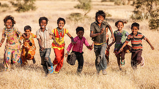 Group of running happy Indian children, desert village, India "Group of running happy Gypsy Indian children - desert village, Thar Desert, Rajasthan, India." india poverty stock pictures, royalty-free photos & images