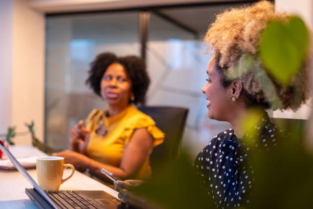 istock Coworkers share a coffee and a conversation in the office while they work 1818917302