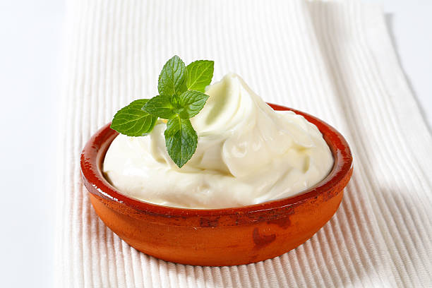 bowl of sour cream fresh sour cream with a mint in an orange ceramic bowl curd cheese stock pictures, royalty-free photos & images