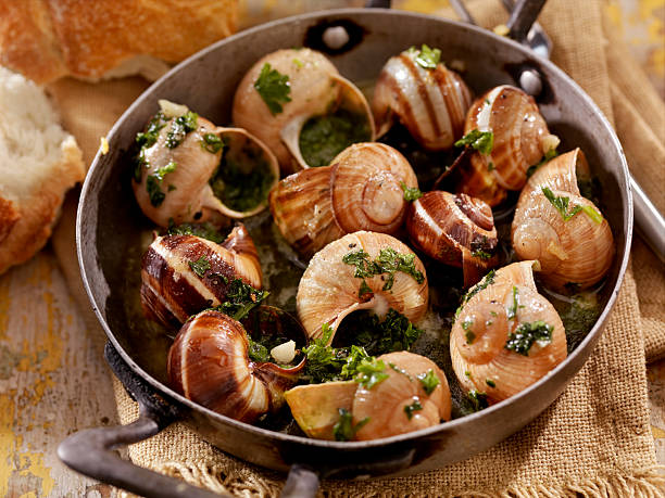snail "Escargot in a Herb Butter, White Wine and Garlic Sauce with Fresh Parsley and Crusty French Bread -Photographed on Hasselblad H3D2-39mb Camera" snail stock pictures, royalty-free photos & images