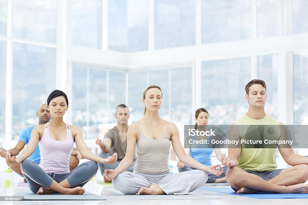 At peace A yoga class meditating in the lotus position - copyspace Adult Stock Photo