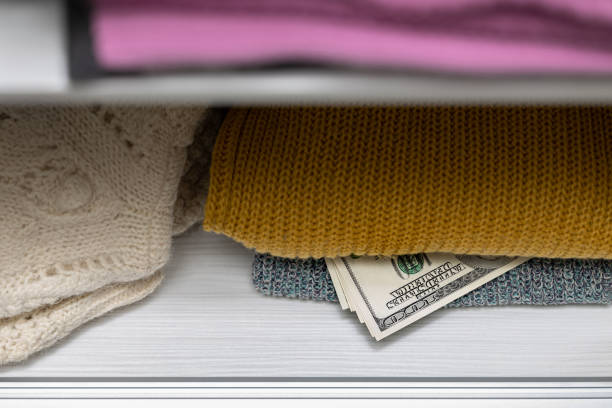 istock American dollars lie under clothes in the closet. 1818926051