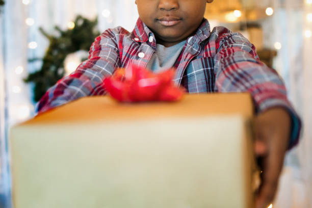 istock Boy Handing Gifts Christmas Morning 1818926076