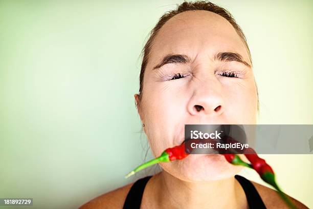 Foto de Ai Mulher Fazendo Careta Lanches Em Muitos Redhot Chillis e mais fotos de stock de Pimenta