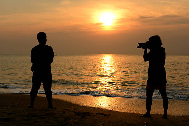 istock Silhouette photographer sitting on the beach 181893005