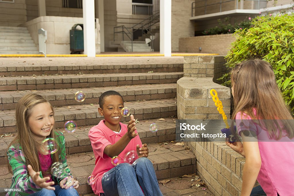 Stile di vita: amicizie Bambino di età scolare studenti a giocare sui passi con bolle - Foto stock royalty-free di 10-11 anni