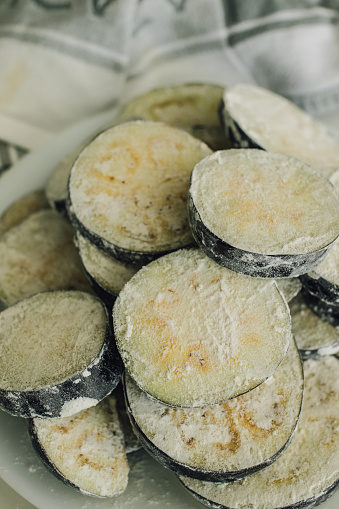 eggplant aubergine slices covered in flour, breaded for frying