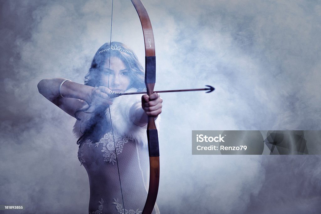 Mysterious Female Archer Portrait of a female archer wearing white dress. (Young woman with bow). Women Stock Photo