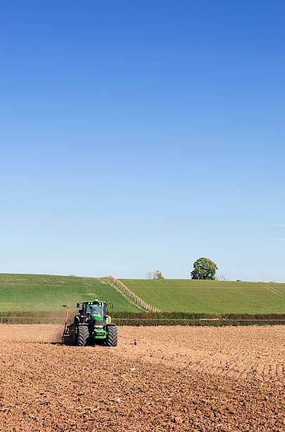 cultivo, plantación de tractor extracción de una semilla de brocas en campo - tractor farm uk agriculture fotografías e imágenes de stock