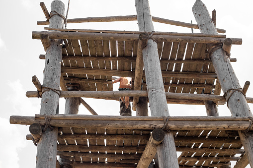 A man climbs a tall wooden watchtower. Travel and tourism.