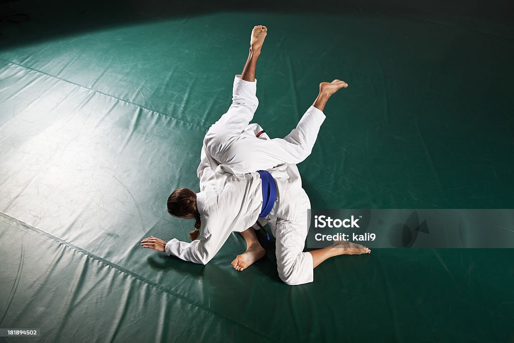Jiu-Jitsu, omopalata escape Young man and woman (20s) practicing Jiu-Jitsu, omopalata escape.   Brazilian jiu-jitsu is a martial art, self defense system and combat sport. Jujitsu Stock Photo