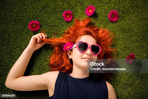 Redhaired Ragazza Con Occhiali Da Sole Seduti Sullerba Nel Parco - Fotografie stock e altre immagini di Fiore