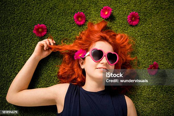 Redhaired Menina Deitada Com Óculos De Sol No Parque Na Grama - Fotografias de stock e mais imagens de Flor