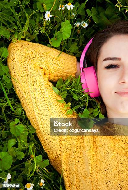 Joven Mujer Escuchando Música Foto de stock y más banco de imágenes de 20-24 años - 20-24 años, Acostado, Acostado boca abajo