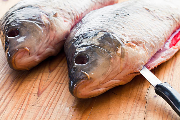 Fresh carp  is cut on the kitchen table stock photo