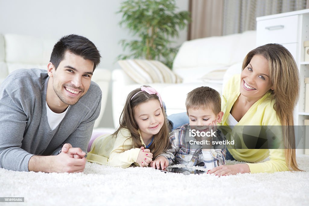 Family. "Happy family lying on floor indoors. Smiling and looking at camera.Please, see more LIFESTYLE images with this FAMILY, some MOTHER'S DAY images and COUPLE alone, for lightbox click the image below." 2-3 Years Stock Photo