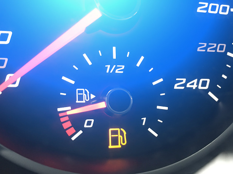 Low fuel gauge in car dashboard. Empty fuel warning light. Low fuel