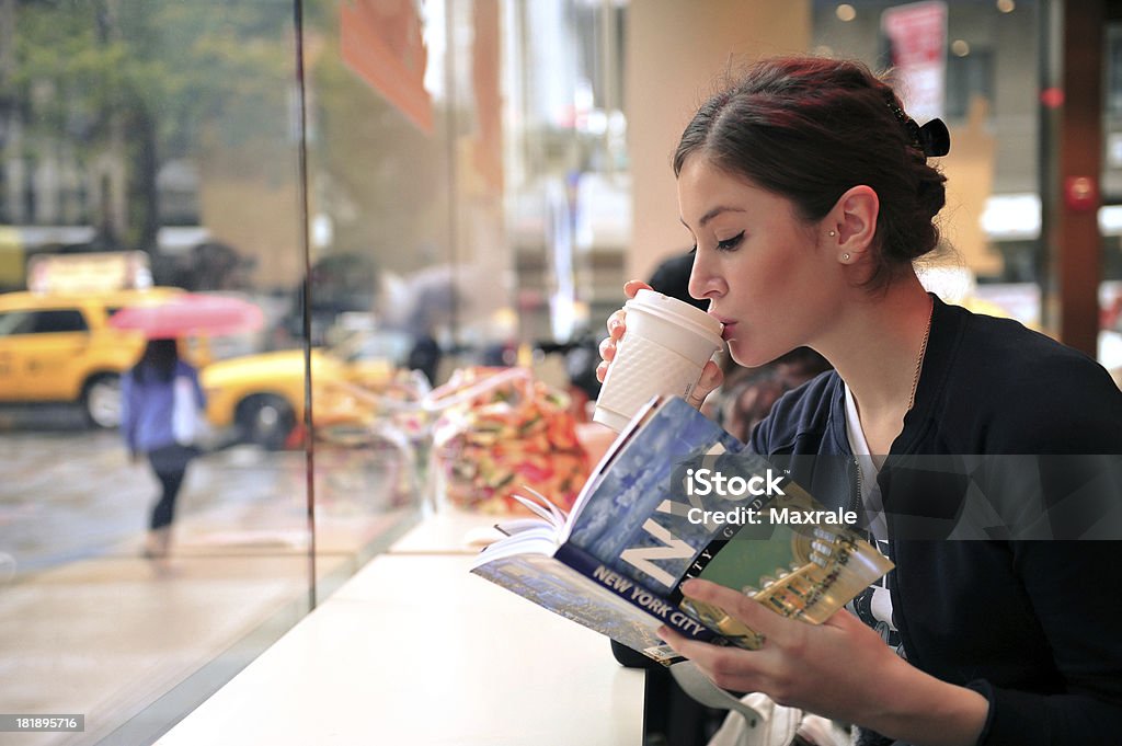 Reading travel guide Nice girl reading NYC travel guide and drinking coffeeGrain additionally addedBook cover images by Maxrale New York City Stock Photo