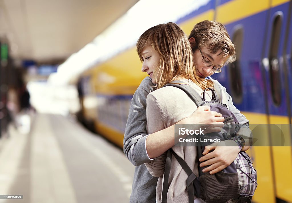 Jovem casal abraçando contra trem no fundo - Foto de stock de Abraçar royalty-free