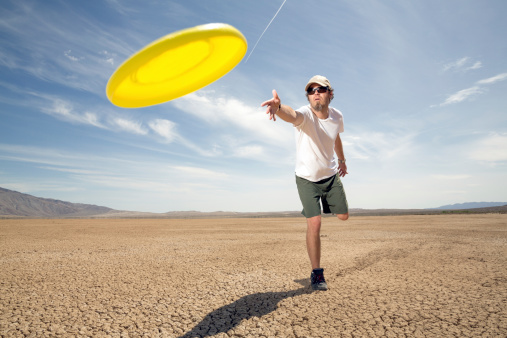 A man tossing a Frisbee.