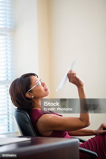Businesswoman Throwing Paper Plane In Office Stock Photo - Download Image Now - Paper Airplane, Adult, Holding