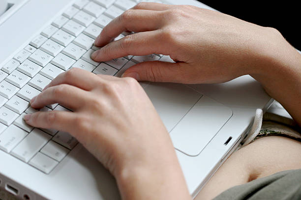 Close-up of girl typing on laptop stock photo