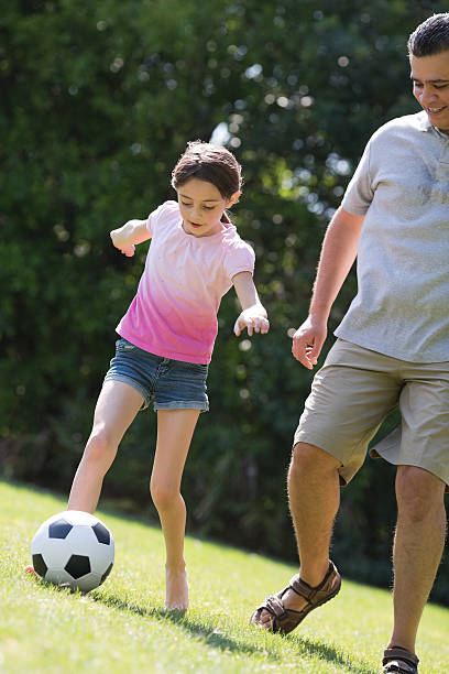 istock Father And Daughter Playing Soccer 181897389