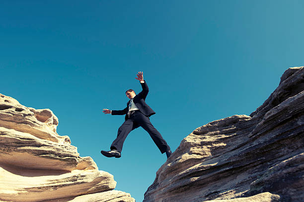 istock Risk concept. Businessman jumping across a ravine. 181897572