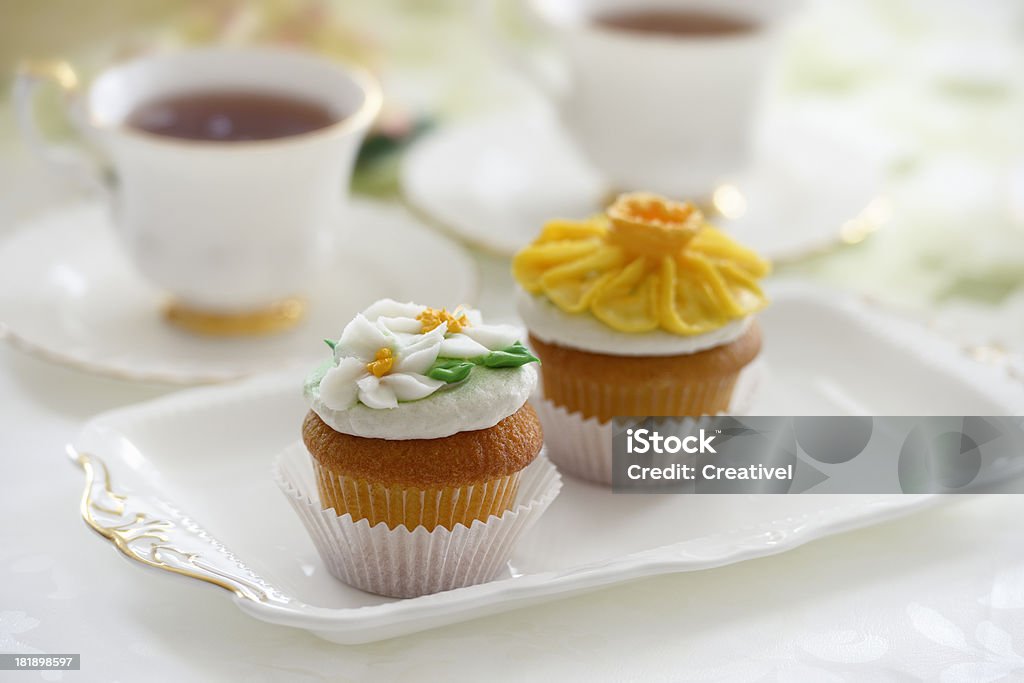 Пирожные глазурью цветами и чай - Стоковые фото Вечеринка роялти-фри