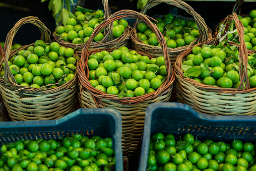 background from green plums , summer fruit green plum sold in open air market , green plums in baskets on stalls in open air market. High quality photo