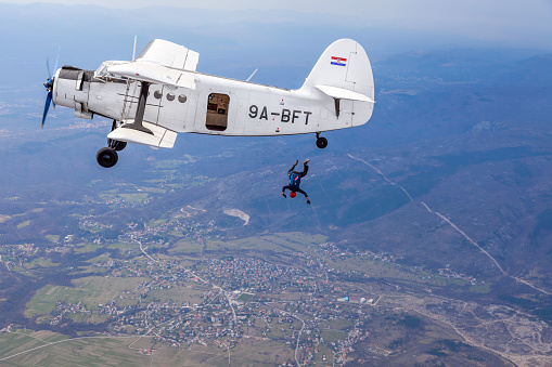 Paramotor pilot and his tourist client flying in the sky