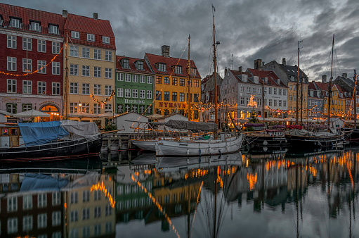 Christmas deocorations reflect in Copenhagen Nyhavn canal at dusk, November 25, 2023