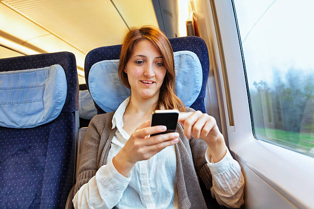 istock Young woman checking her smart phone on train 181899237