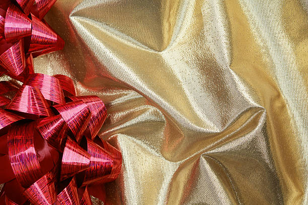 istock Red ribbon on gold fabric 181899515