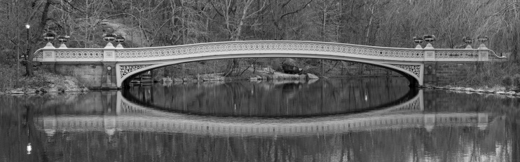 The Gapstow Bridge arches over the nature and The Pond in central park Manhattan New York City USA