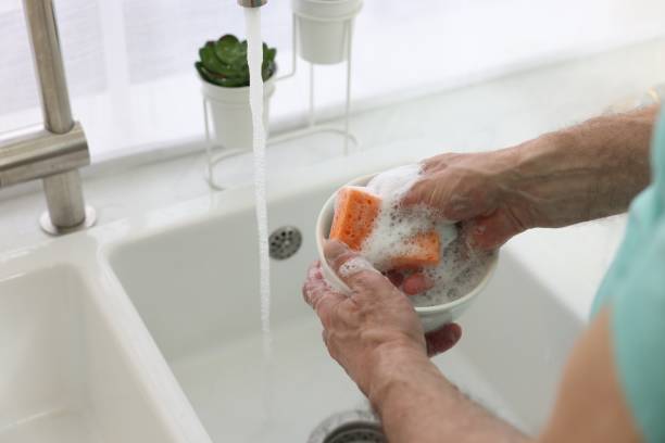 istock Man washing bowl above sink in kitchen, closeup 1818998401