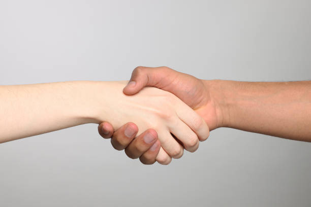 istock International relationships. People shaking hands on light grey background, closeup 1819000067