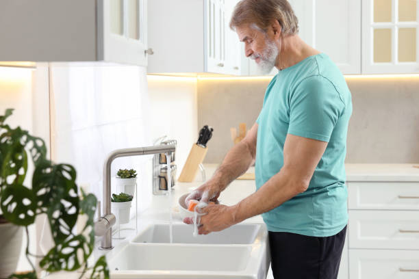 istock Senior man washing bowl above sink in kitchen 1819000577