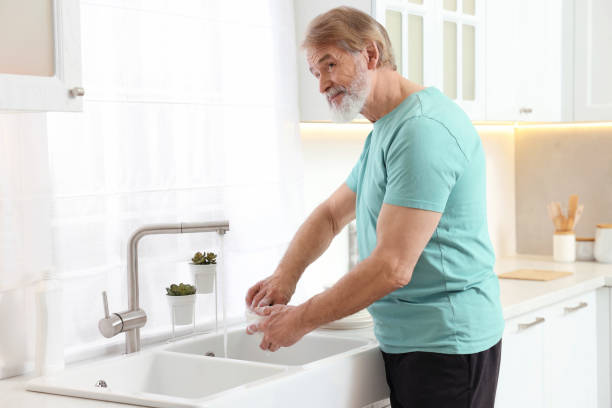 istock Senior man washing bowl above sink in kitchen 1819000578