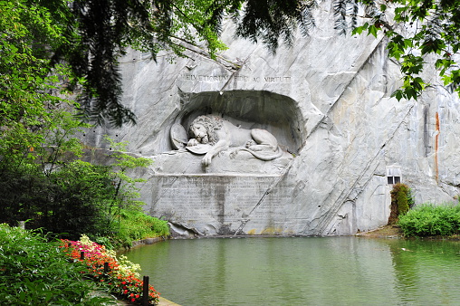 The mournful Lion Monument of Lucerne that commemorates the Swiss Guards who were massacred in 1792 during the French Revolution. The Lion Monument was designed by Bertel Thorvaldsen (1770-1884), a classicist Danish sculptor in 1819 while he stayed in Rome, Italy. Lucas Ahorn (1789-1856), a stone-mason from Constance (southern Germany) actually carved it out of the sandstone rock in 1820/1821. The Lion Monument was inaugurated on August 10, 1821. Originally the site was private property. In 1882 the city of Lucerne bought it. The site is open to the public and accessible without an entrance fee. The monument soon became one of Lucerne's major tourist attractions.