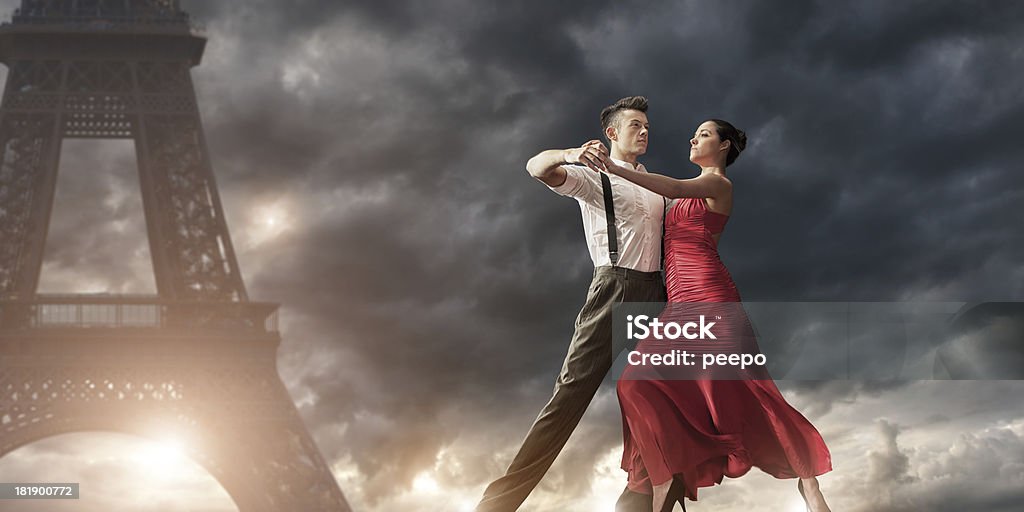 Romantic Evening Dance in Paris two retro styled dancers in formal dress dancing near Eiffel tower in Paris under stormy sky at sunset Dancing Stock Photo