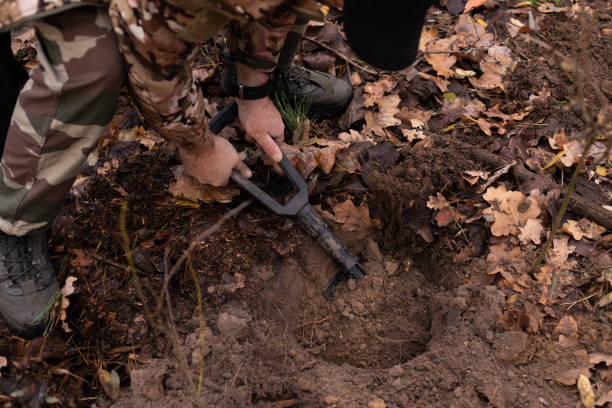 istock a man in military uniform digging a hole in the woods with a sapper shovel 1819009373