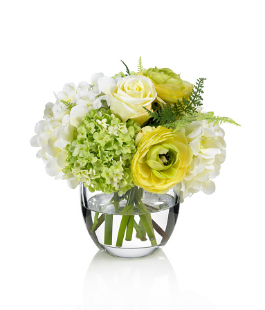 A yellow rose, ranunculus and hydrangea bouquet in a round glass vase. Shot against a bright white background. There is a path which may be used to delete the reflection if desired. Extremely high quality faux flowers.