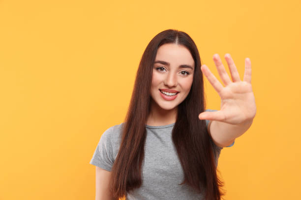 istock Happy woman giving high five on orange background, space for text 1819013291